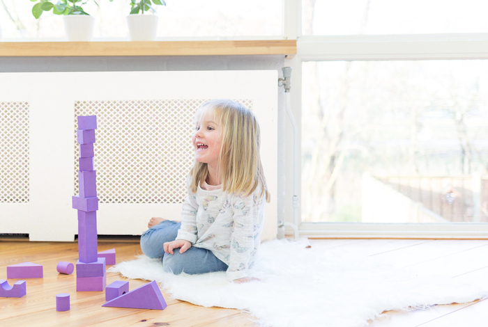 Meisje speelt met paarse blokken voor verwarming
