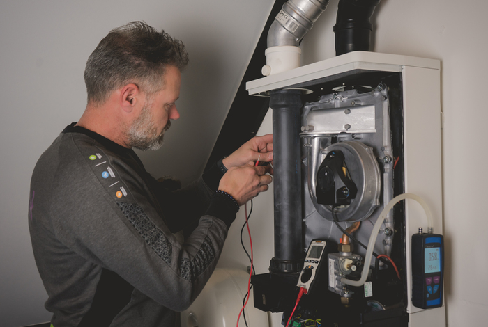 ESNW monteur inspecteert de muur op asbest