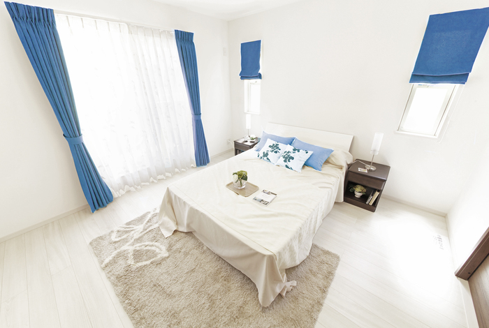 Slaapkamer met grote ramen en blauwe gordijnen
